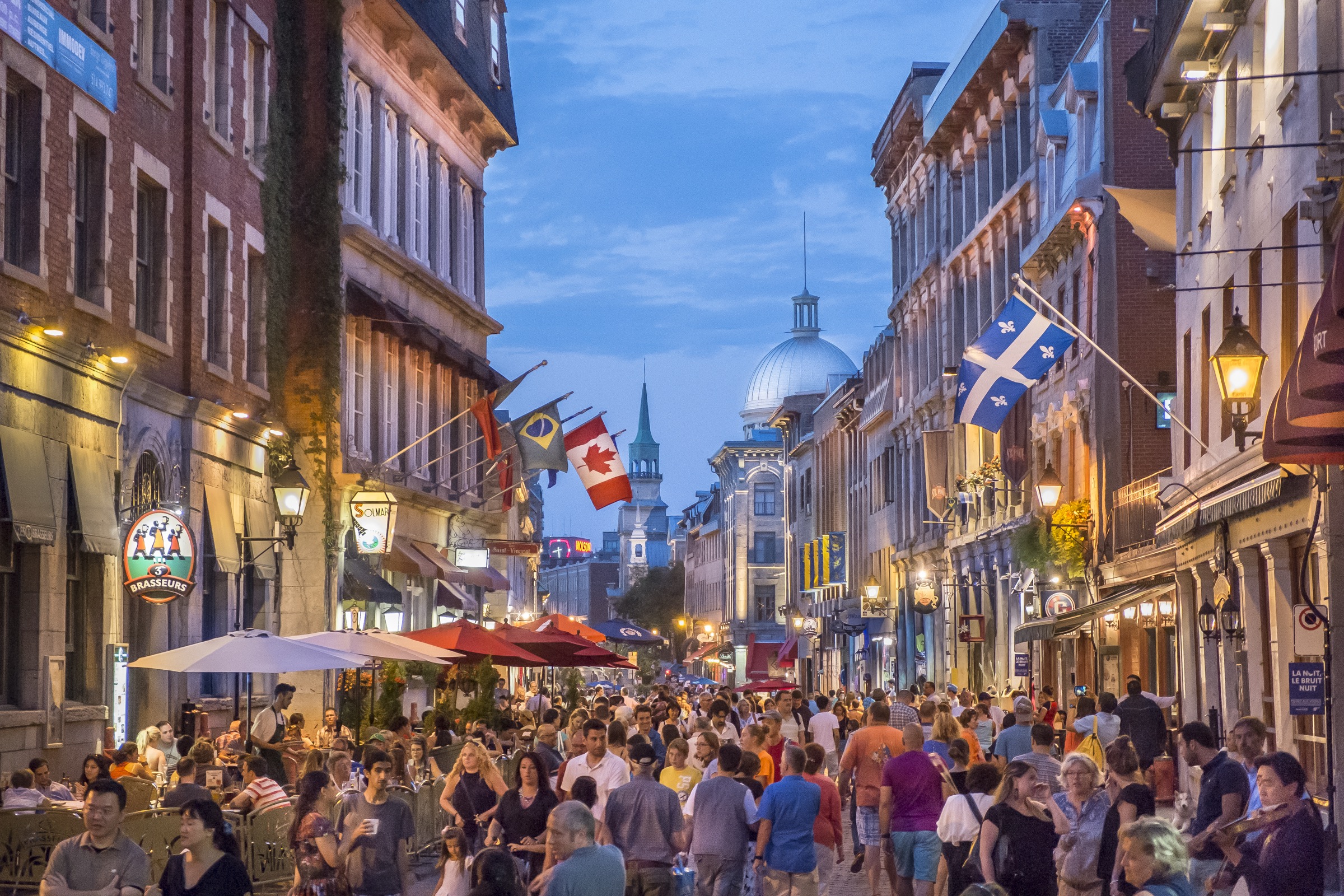 Rue Saint-Paul in Vieux-Montréal at evening — warm restaurant terraces and cobblestone street, the walkable downtown spine for race weekend — © Tourisme Montréal, Stéphan Poulin